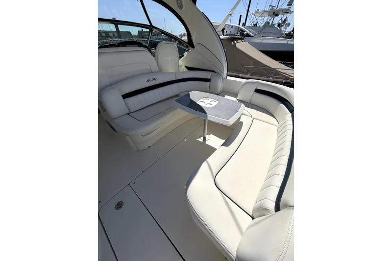 Slide: The Image of 2006 Sea Ray 40 Sundancer interior with white seating and table, docked at marina. - 45