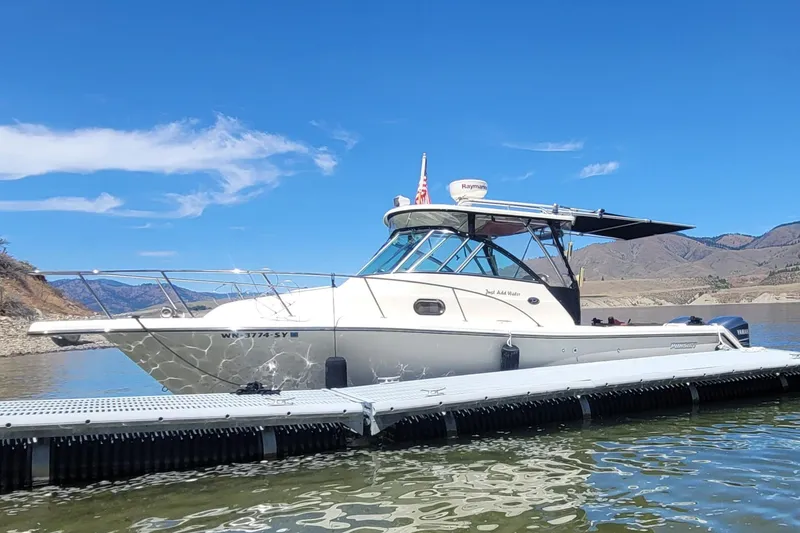 The Image of 2007 Pursuit OS 285 Offshore boat docked on a sunny day with scenic mountain backdrop. - 4