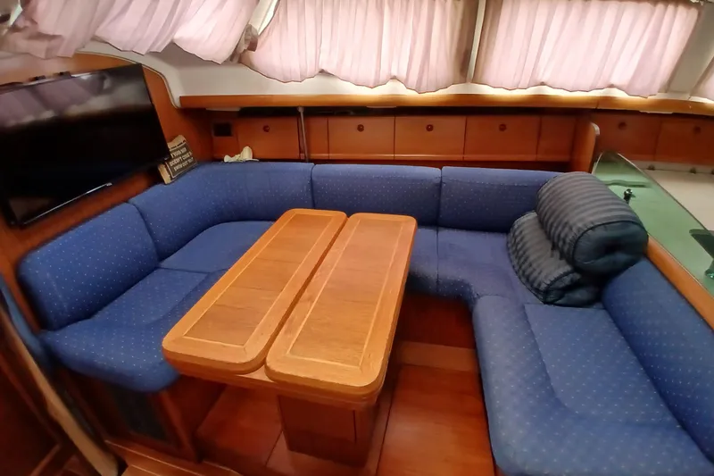 Slide: The Image of Interior of 2002 Jeanneau Sun Odyssey 43 DS with blue seating and wooden table. - 11