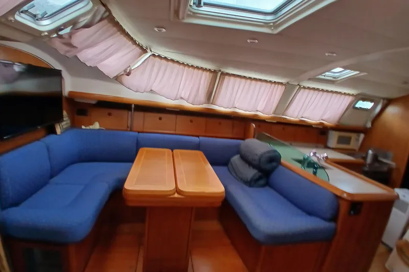 Slide: The Image of Interior of 2002 Jeanneau Sun Odyssey 43 DS yacht with blue seating and wooden table. - 12