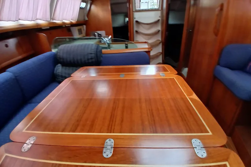 Slide: The Image of Interior of 2002 Jeanneau Sun Odyssey 43 DS with wooden table and blue seating. - 13