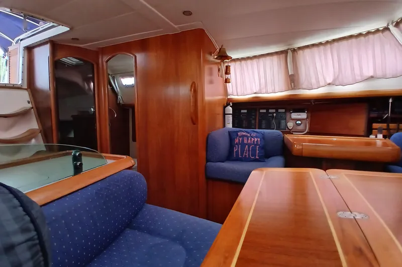 Slide: The Image of Interior of 2002 Jeanneau Sun Odyssey 43 DS yacht with wooden furnishings and blue seating. - 17