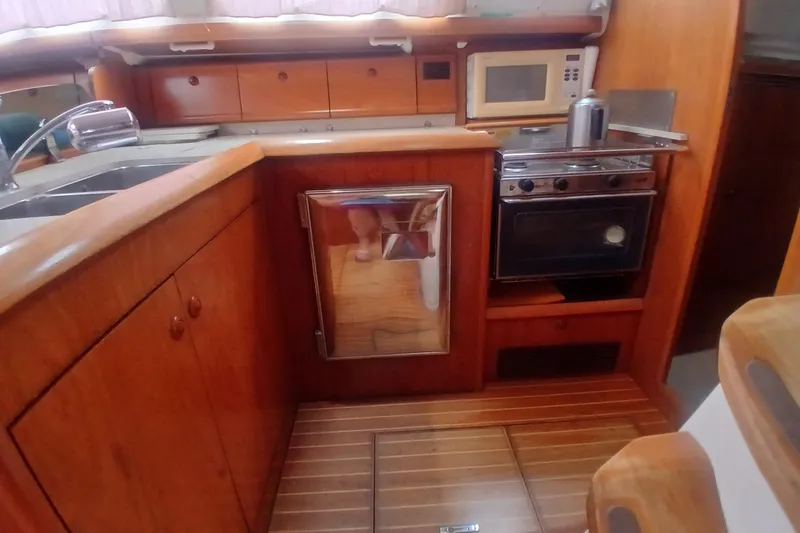 Slide: The Image of Galley kitchen in 2002 Jeanneau Sun Odyssey 43 DS sailboat with wood cabinetry and appliances. - 22
