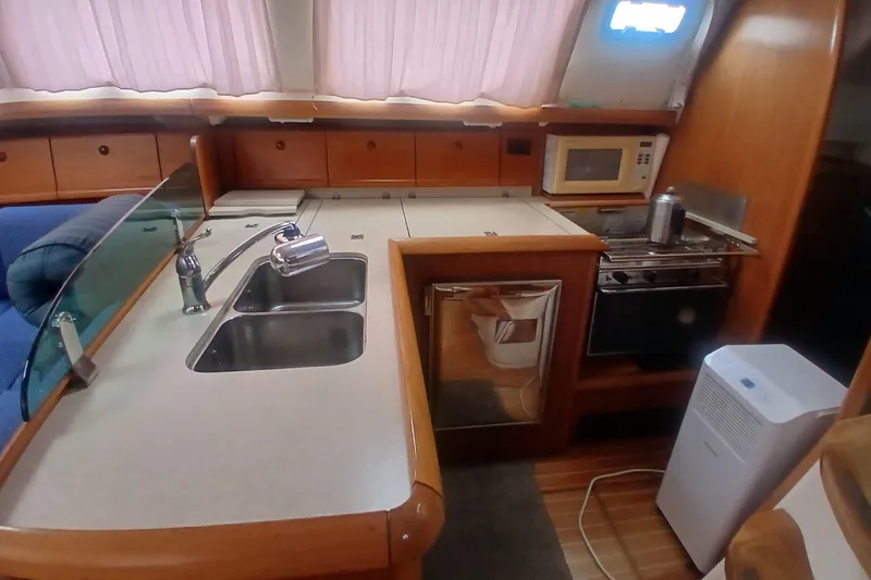 Slide: The Image of Interior of 2002 Jeanneau Sun Odyssey 43 DS yacht kitchen with sink, stove, and microwave. - 23