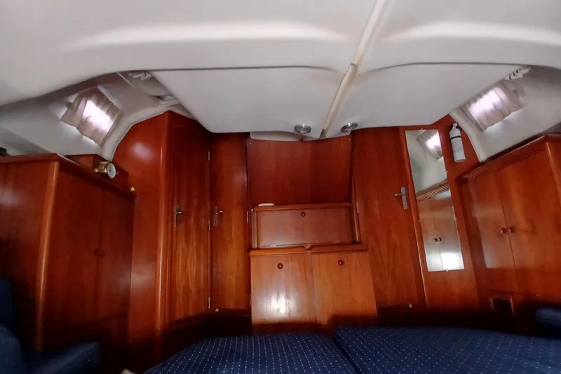 Slide: The Image of Interior of 2002 Jeanneau Sun Odyssey 43 DS, featuring wooden cabinetry and cozy seating. - 34