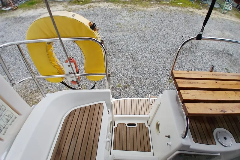 Slide: The Image of Cockpit view of 2002 Jeanneau Sun Odyssey 43 DS with wooden seating and yellow life ring. - 48