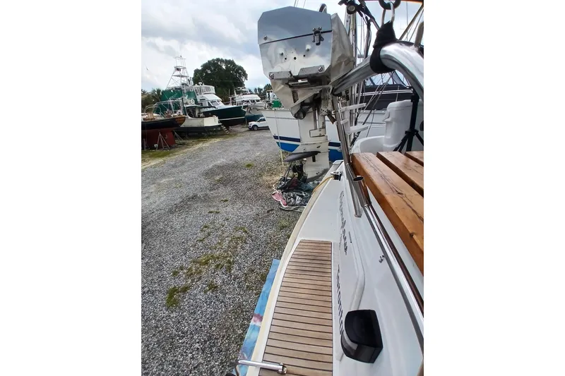 Slide: The Image of 2002 Jeanneau Sun Odyssey 43 DS sailboat on gravel, with visible deck and outboard motor. - 50