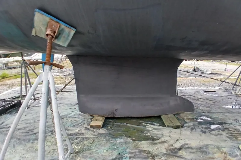 Slide: The Image of Keel of 2002 Jeanneau Sun Odyssey 43 DS sailboat on stands for maintenance. - 54