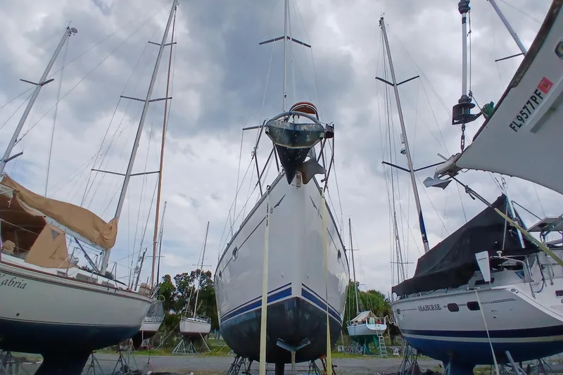 Slide: The Image of 2002 Jeanneau Sun Odyssey 43 DS sailboat in dry dock, surrounded by other vessels. - 55