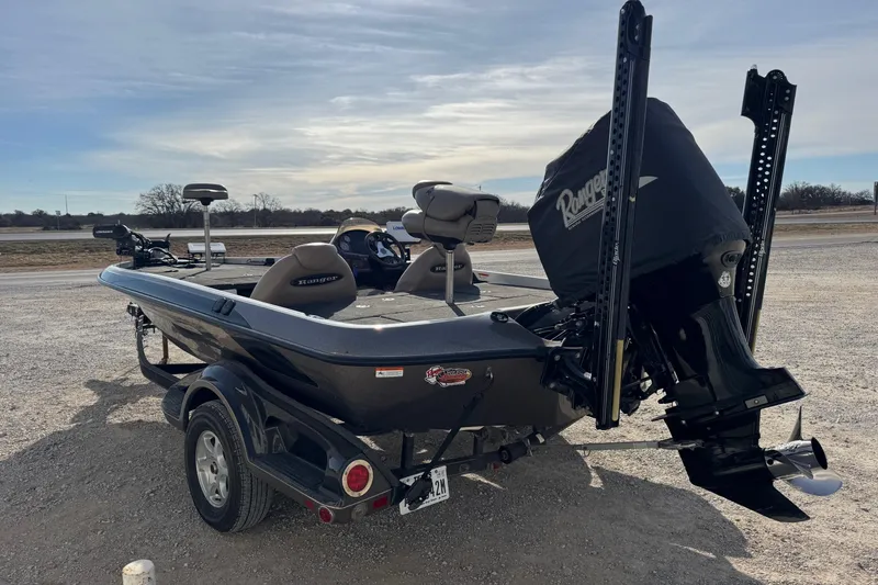 Slide: The Image of 2006 Ranger 519 VX boat on trailer, parked outdoors under a cloudy sky. - 3