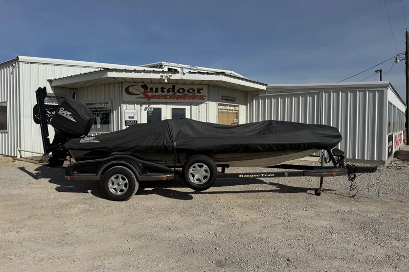 Slide: The Image of 2006 Ranger 519 VX boat covered on trailer outside dealership. - 9