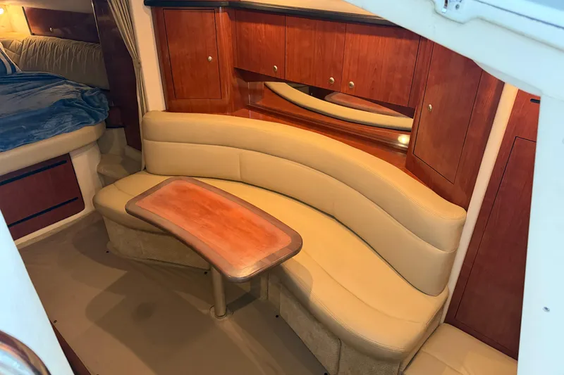 Slide: The Image of 2007 Sea Ray Sundancer 320 interior with curved seating and wooden cabinetry. - 18