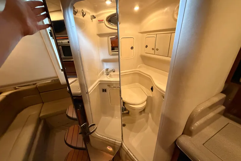 Slide: The Image of Interior of 2007 Sea Ray Sundancer 320 yacht, featuring a compact bathroom and seating area. - 22