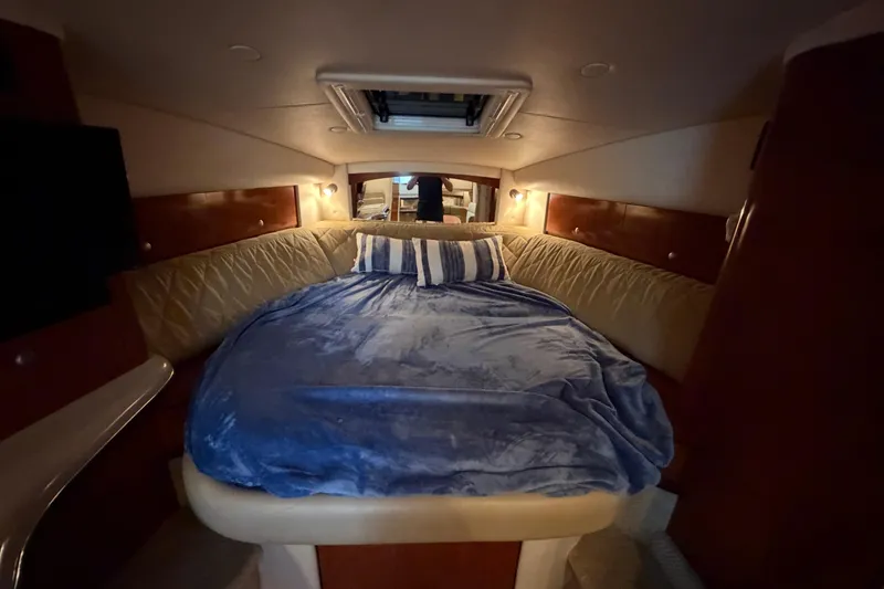 Slide: The Image of Cozy cabin interior of 2007 Sea Ray Sundancer 320 with plush bedding and ambient lighting. - 26
