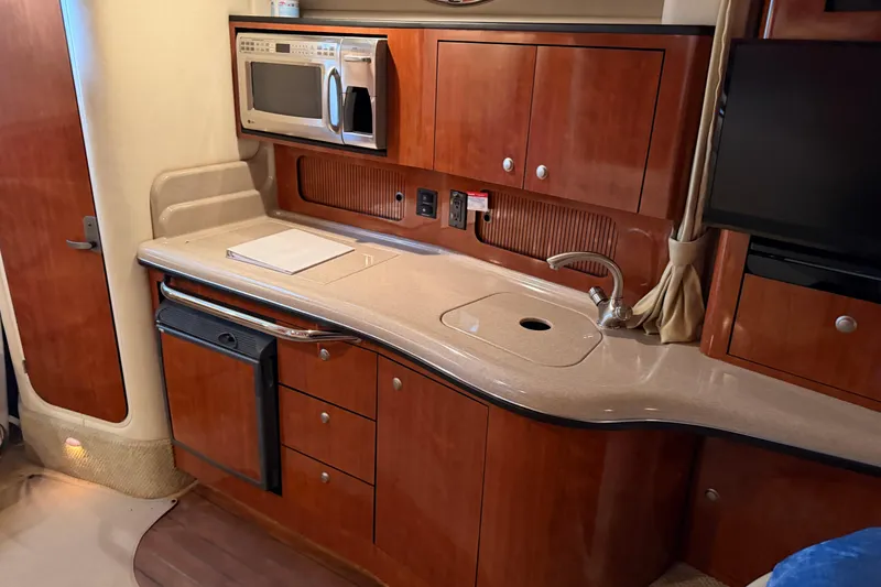 Slide: The Image of Luxurious 2007 Sea Ray Sundancer 320 yacht kitchen with wood cabinetry and modern appliances. - 29
