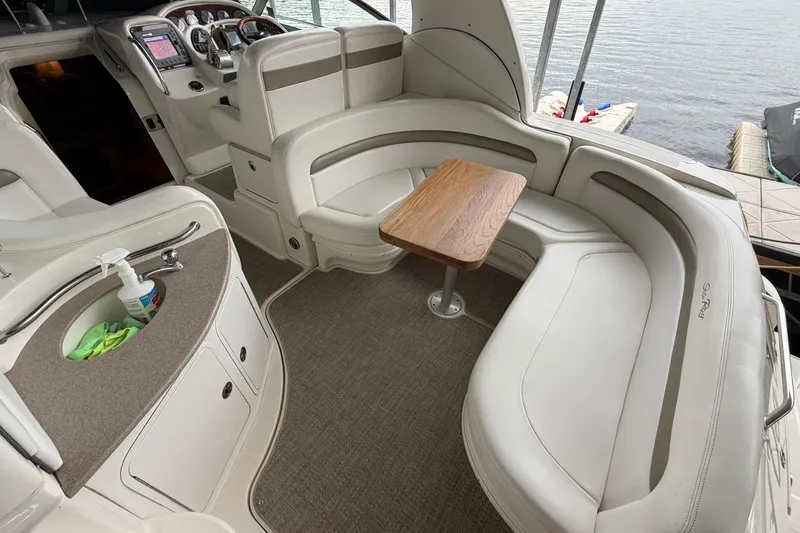 Slide: The Image of 2007 Sea Ray Sundancer 320 interior with white seating, wooden table, and helm controls. - 6