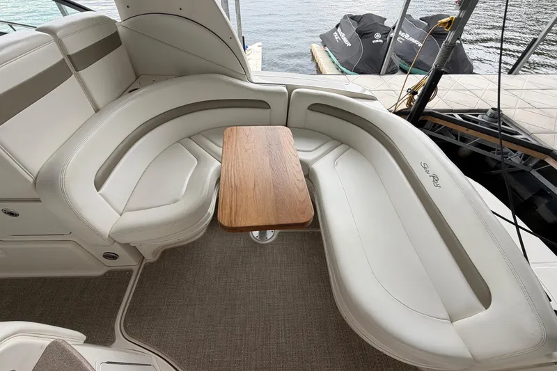 Slide: The Image of 2007 Sea Ray Sundancer 320 interior with curved seating and wooden table. - 8