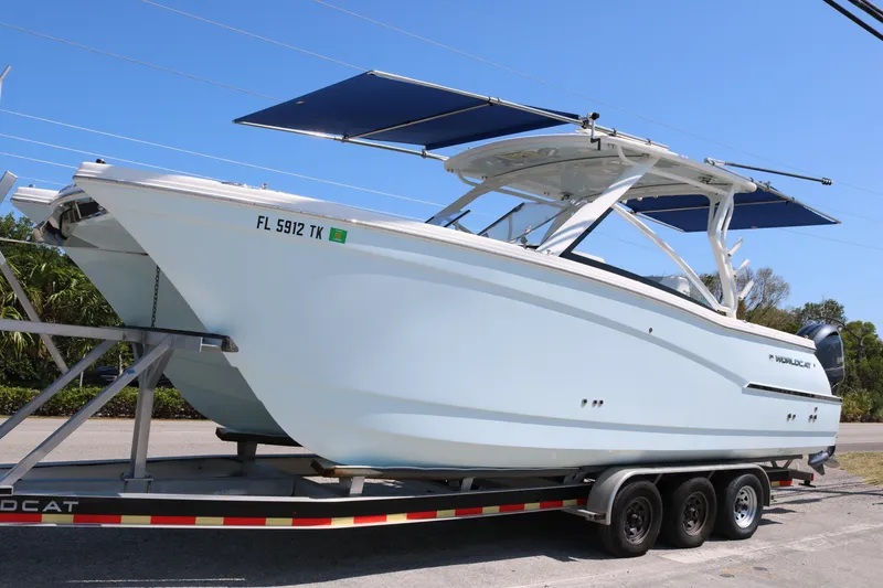 Slide: The Image of 2023 World Cat 280 DC-X boat on trailer, featuring sleek design and dual engines. - 1