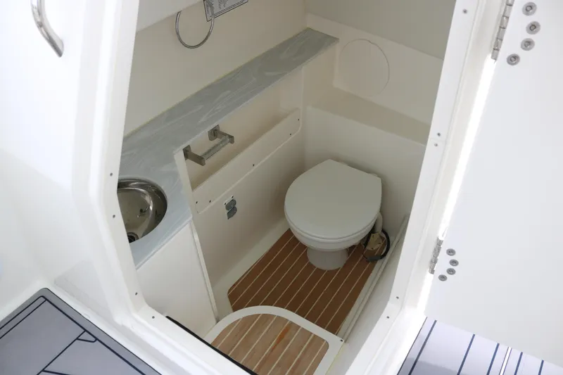 Slide: The Image of Interior of 2023 World Cat 280 DC-X boat bathroom with toilet and sink. - 11