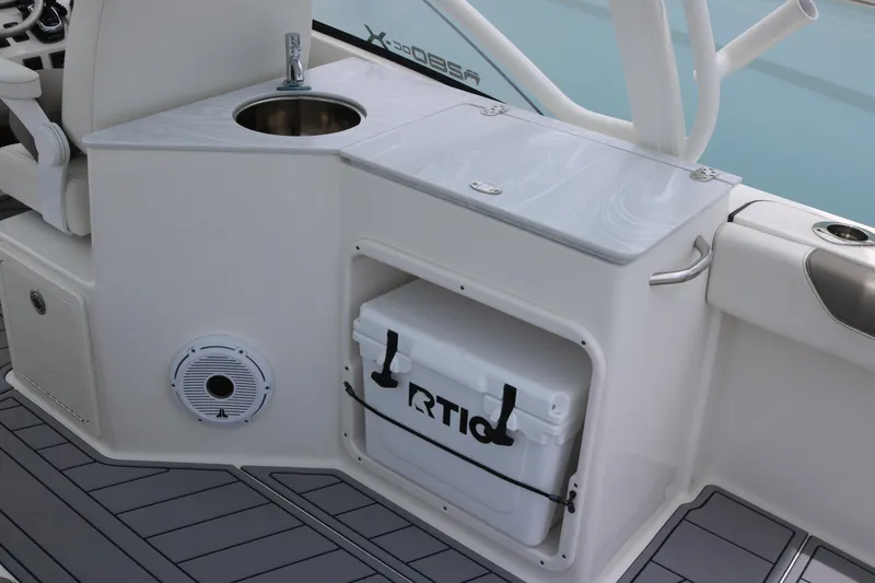 Slide: The Image of 2023 World Cat 280 DC-X boat interior with sink, storage, and cooler. - 12