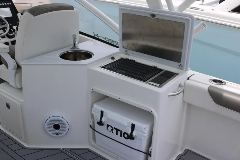 Slide: The Image of 2023 World Cat 280 DC-X boat interior with grill, sink, and cooler. - 13