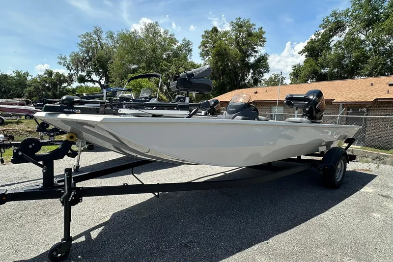The Image of 2026 Tracker Pro Team 170 TX boat on trailer, parked outdoors under clear sky. - 1
