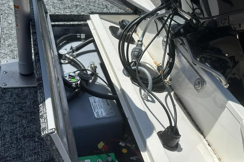 Slide: The Image of Open engine compartment of 2026 Tracker Pro Team 170 TX boat, showing wiring and components. - 17
