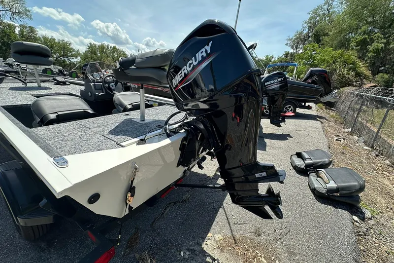 Slide: The Image of 2026 Tracker Pro Team 170 TX boat with Mercury outboard motor, parked outdoors. - 19