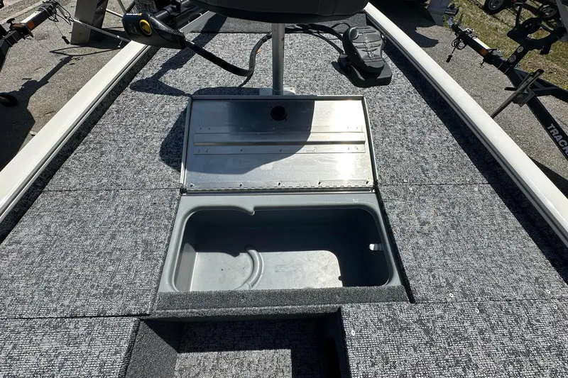 Slide: The Image of 2026 Tracker Pro Team 170 TX boat with open storage compartment on carpeted deck. - 5