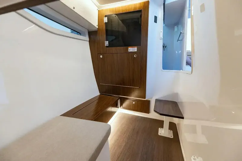 Slide: The Image of Manufacturer Provided Image: Interior cabin of 2026 Four Winns H33 OB boat with wood accents and seating. - 6