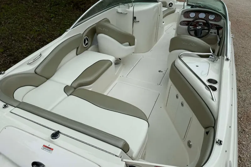 Slide: The Image of 2006 Sea Ray 240 Sundeck interior with beige and white seating, sleek design. - 11