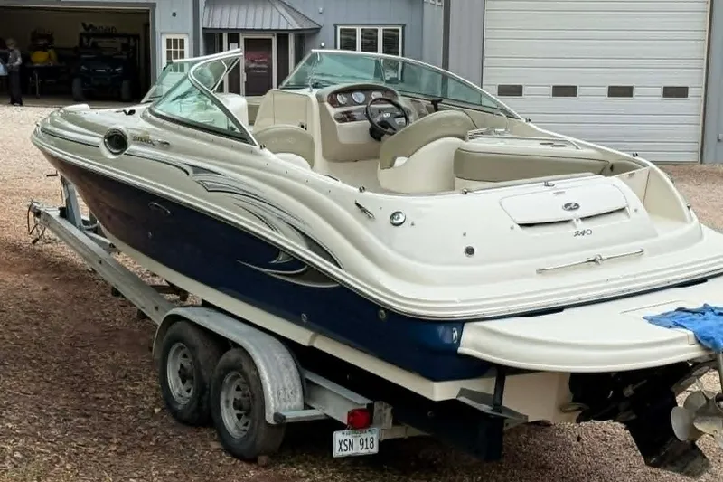 Slide: The Image of 2006 Sea Ray 240 Sundeck boat on trailer, parked outside a garage. - 12