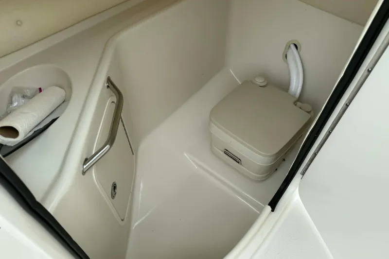 Slide: The Image of 2006 Sea Ray 240 Sundeck boat interior with portable toilet and storage compartment. - 13