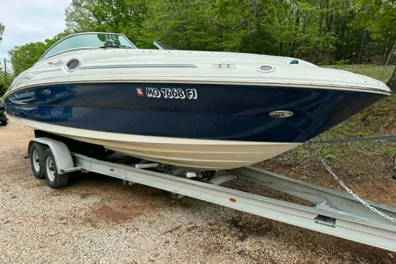 Slide: The Image of 2006 Sea Ray 240 Sundeck boat on trailer, parked outdoors. - 14