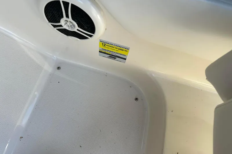 Slide: The Image of 2006 Sea Ray 240 Sundeck interior showing speaker and capacity label for 12 persons. - 5