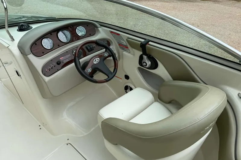 Slide: The Image of 2006 Sea Ray 240 Sundeck helm with gauges, steering wheel, and comfortable seating. - 7