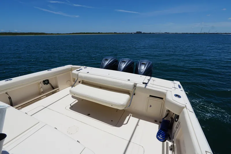 Slide: The Image of 2020 Grady-White Canyon 376 boat deck with triple outboard motors on open water. - 11
