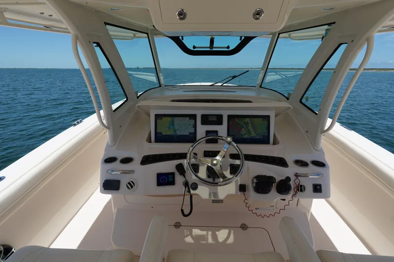 Slide: The Image of 2020 Grady-White Canyon 376 helm with dual displays, steering wheel, and ocean view. - 16