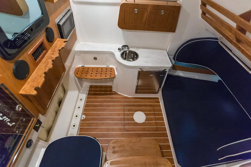 Slide: The Image of Manufacturer Provided Image: 2020 Grady-White Canyon 376 cabin interior with wooden flooring, sink, and seating area. - 23