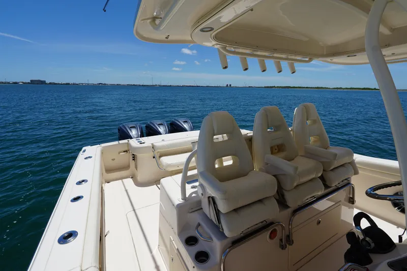 Slide: The Image of 2020 Grady-White Canyon 376 boat interior with seating, ocean view, and triple outboard motors. - 7