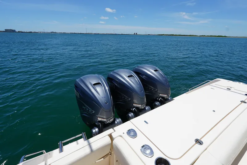 Slide: The Image of 2020 Grady-White Canyon 376 boat with triple outboard motors on open water. - 8