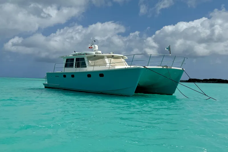 The Image of Catamaran Maine Cat P-47, 2011 model, anchored in turquoise waters under cloudy skies. - 1