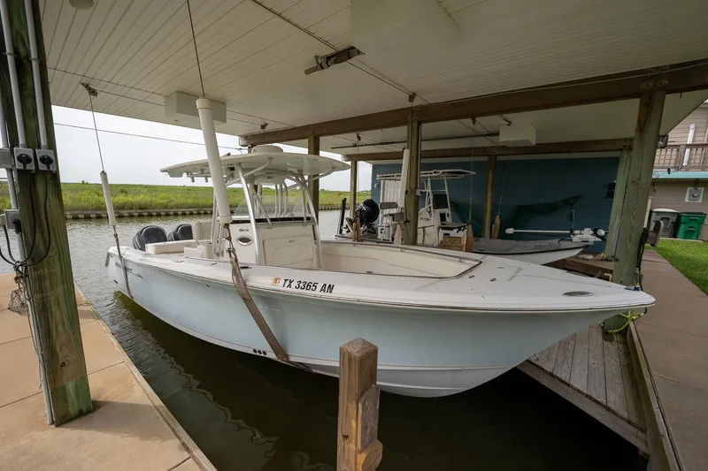 The Image of 2007 Sea Hunt Triton 290 boat docked under covered marina. - 0