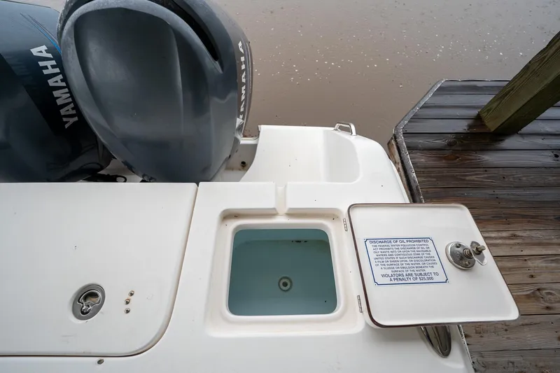 Slide: The Image of 2007 Sea Hunt Triton 290 boat stern with Yamaha engines and open storage compartment. - 15