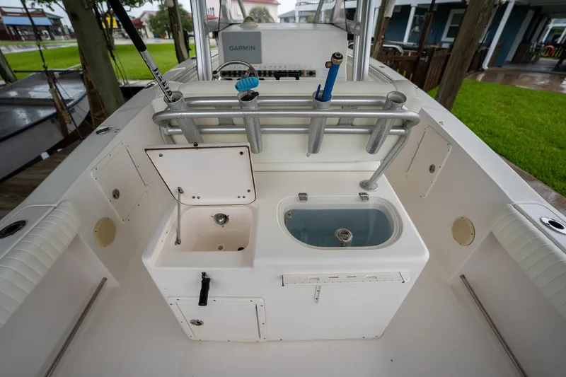 Slide: The Image of 2007 Sea Hunt Triton 290 boat deck with fishing rod holders and storage compartments. - 17