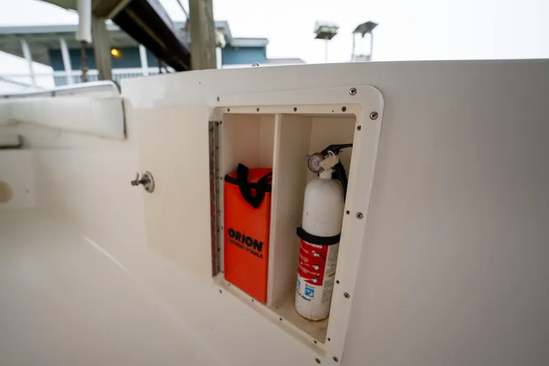 Slide: The Image of Storage compartment on a 2007 Sea Hunt Triton 290 boat with safety equipment. - 19
