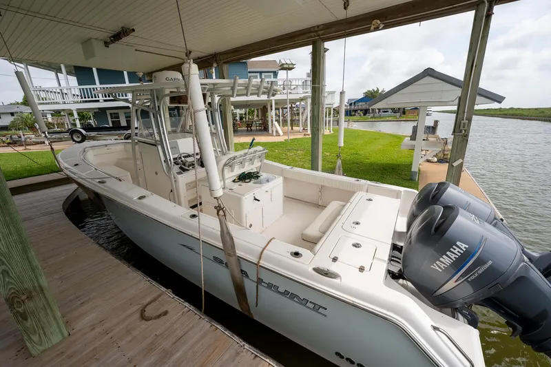 Slide: The Image of 2007 Sea Hunt Triton 290 boat docked with dual Yamaha engines, under a covered slip. - 2