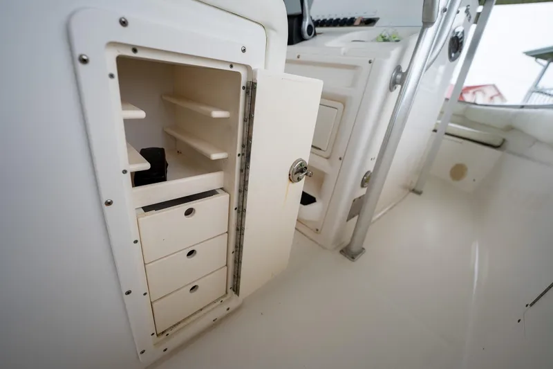 Slide: The Image of 2007 Sea Hunt Triton 290 boat storage compartment with open shelves and drawers. - 20