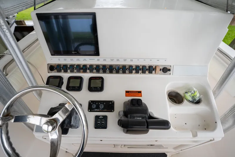 Slide: The Image of 2007 Sea Hunt Triton 290 helm with steering wheel, controls, and navigation display. - 23