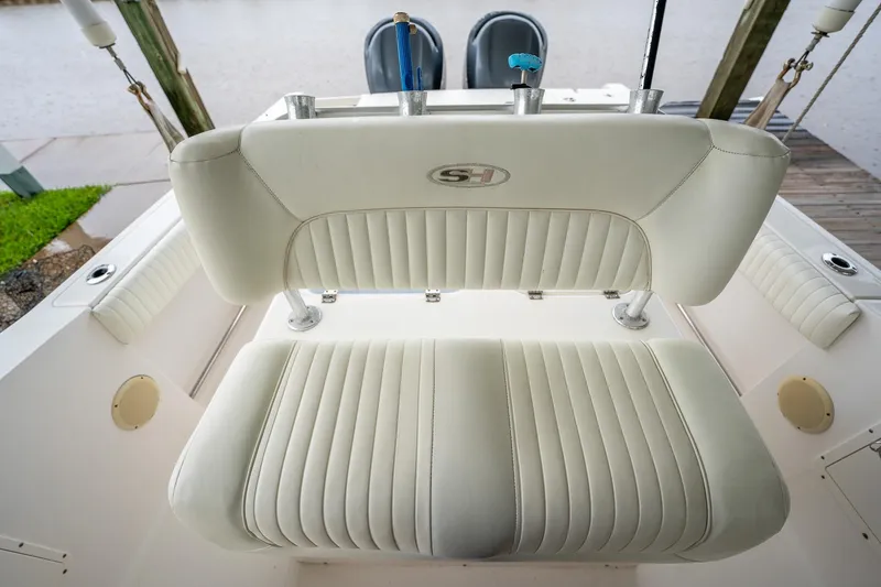 Slide: The Image of 2007 Sea Hunt Triton 290 boat with white cushioned seating and fishing rod holders. - 24
